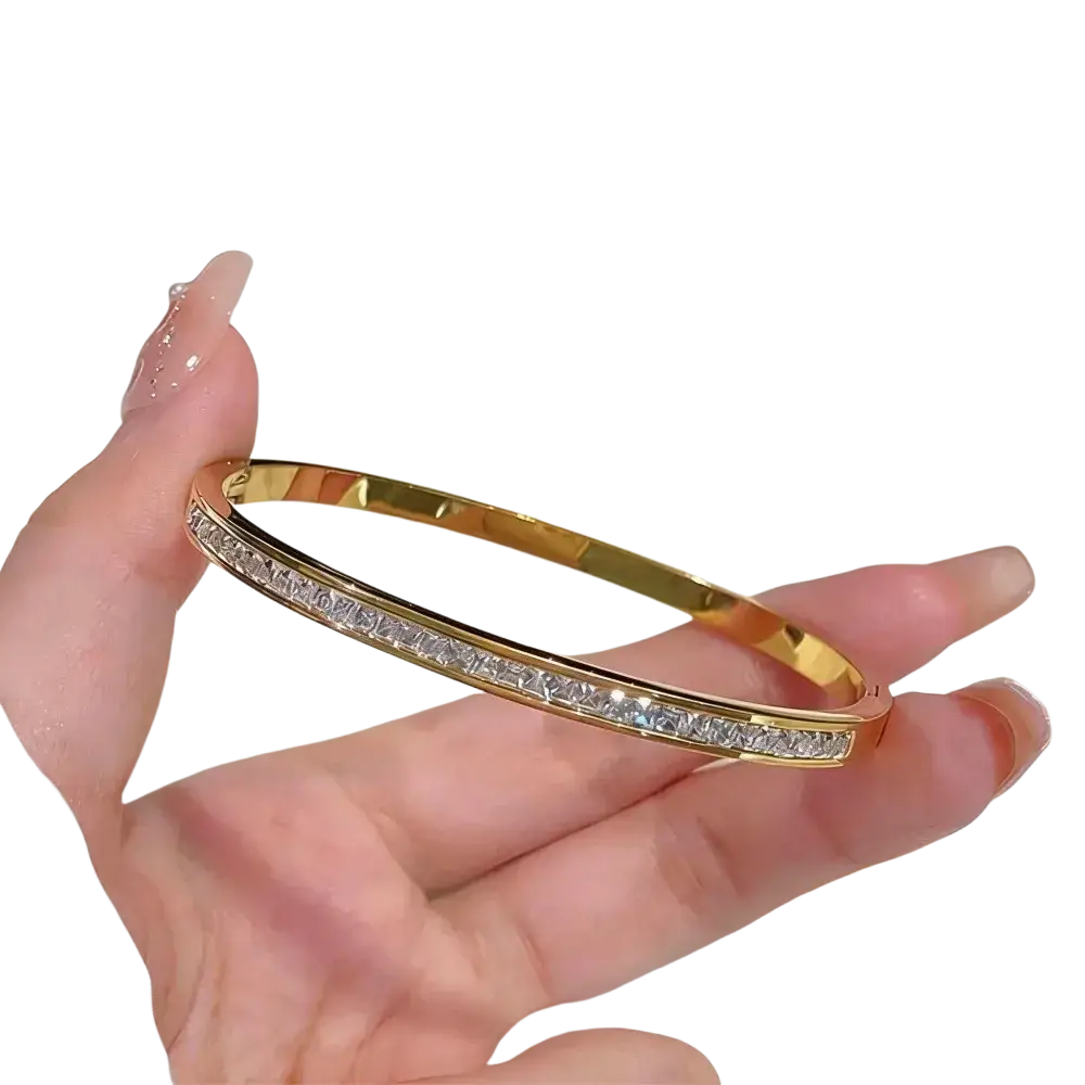 Stainless steel gold-toned bangle bracelet with a continuous row of clear rectangular-cut stones for women
