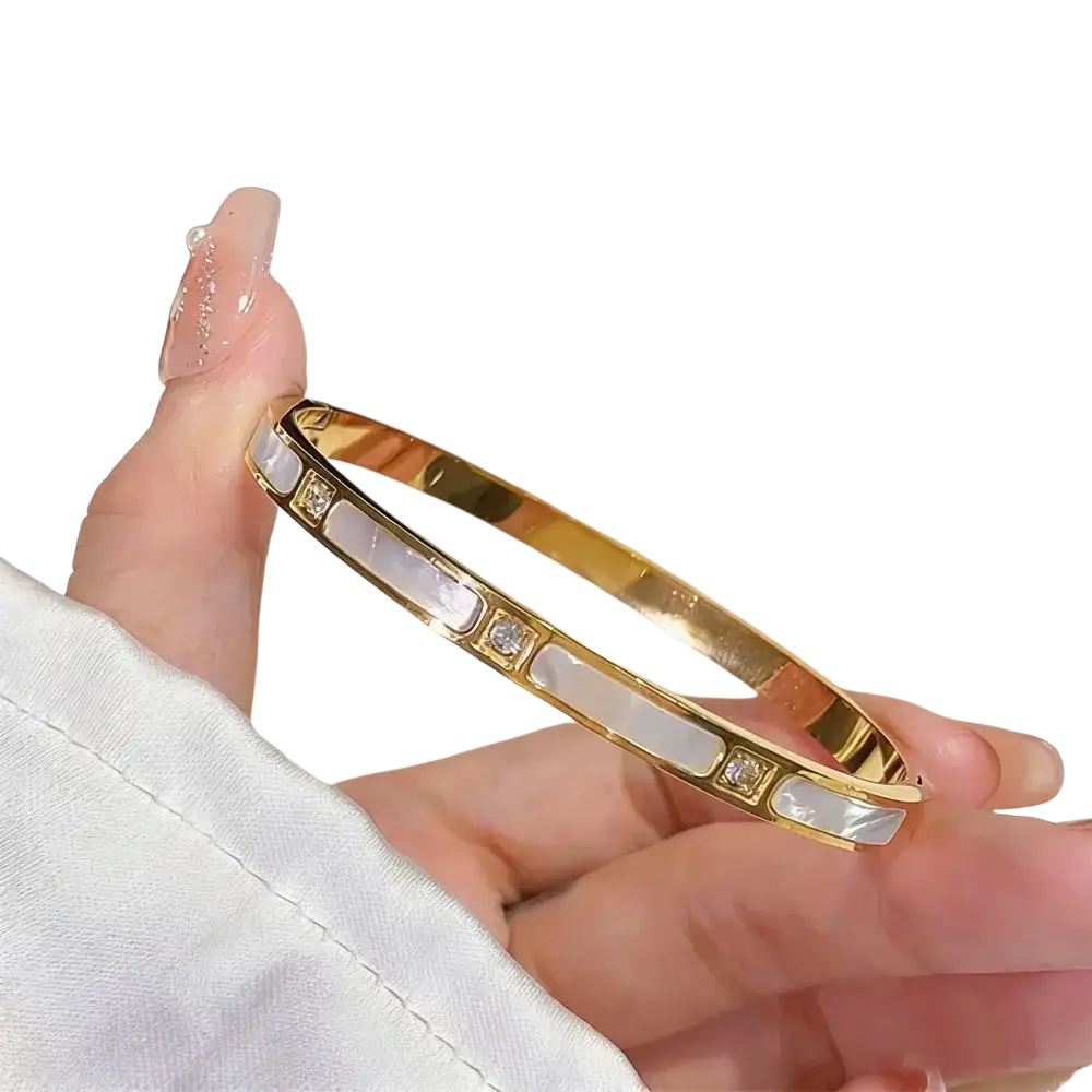 Gold-toned stainless steel bangle bracelet with mother-of-pearl segments and small sparkling diamonds for women