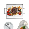Rectangular stainless steel griddle with two side handles featuring grilled steak and roasted vegetables on surface