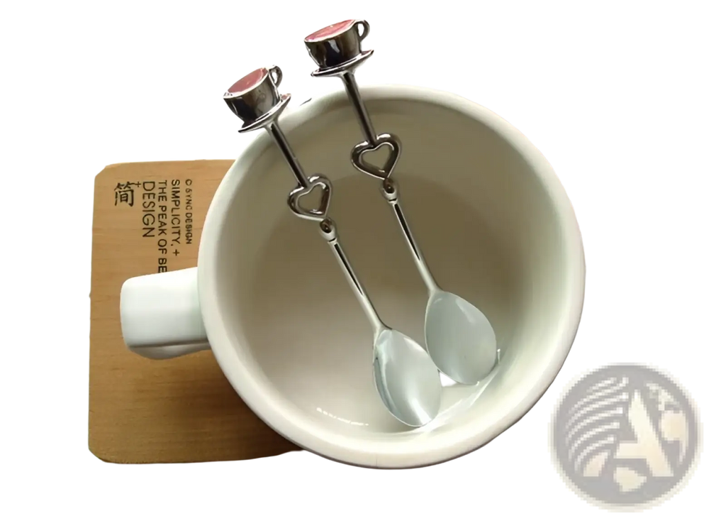 Two silver-toned stainless steel heart coffee spoons with red enamel accented miniature teacup tops and handles