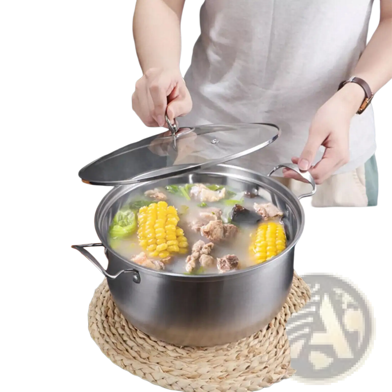 Stainless steel induction cookware pot with clear glass lid and side handles filled with simmering broth and vegetables