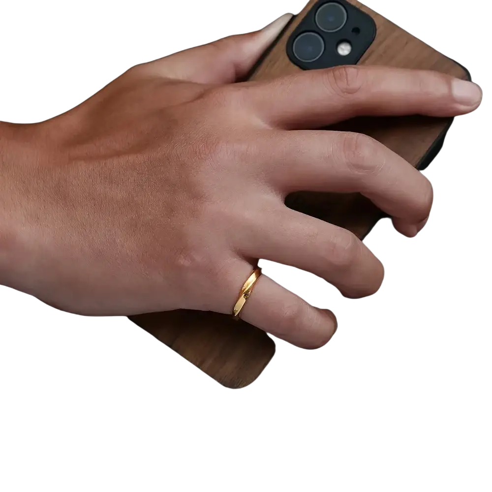 A sleek gold rope twisted stainless steel ring with subtle textured band worn on the middle finger