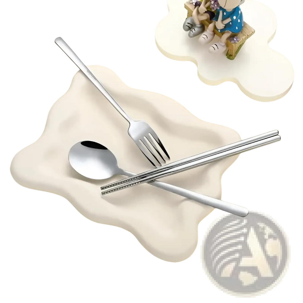 Silver stainless steel travel cutlery set with spoon fork and chopsticks on off-white ceramic bear-shaped dish