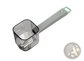 Gray and light green plastic measuring scoop with transparent square bowl beside stainless steel vegetable peeler with gray handle