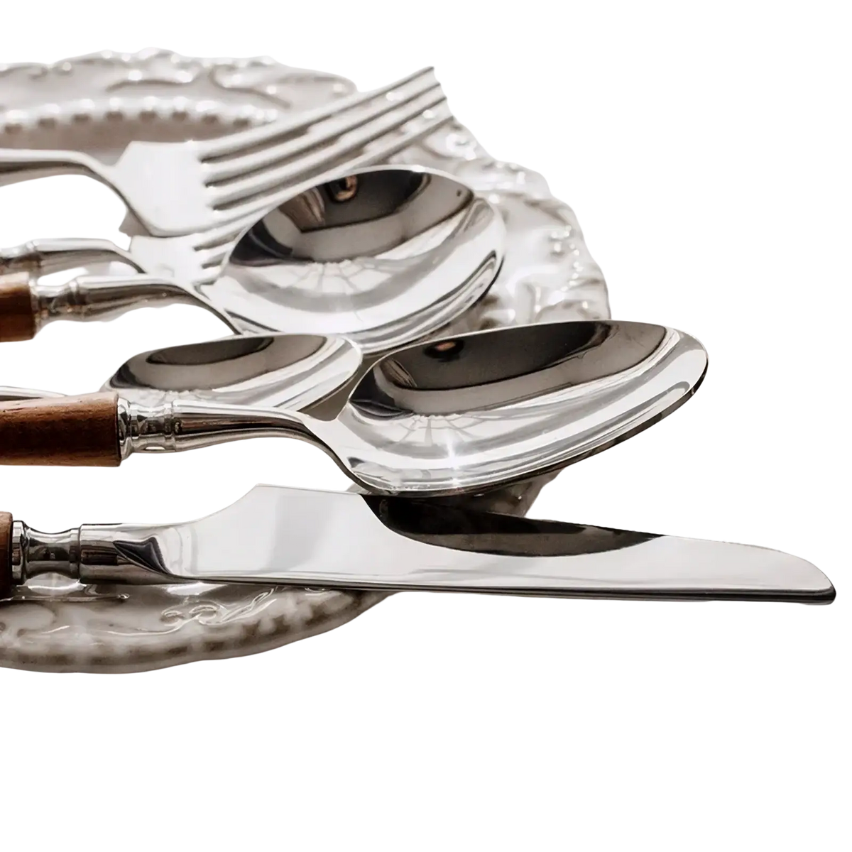 Stainless steel wooden handle cutlery set featuring shiny silver spoons with warm brown handles on a decorative plate