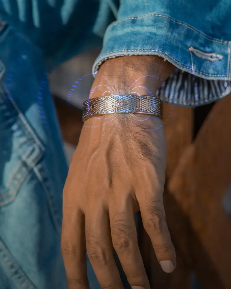 Silver-toned stamped Celtic mist magnetic copper cuff bracelet with intricate geometric engraving worn on wrist
