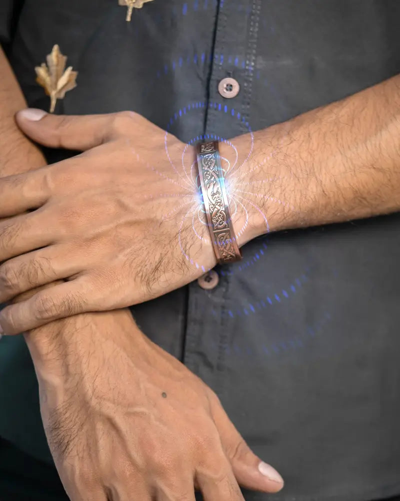 A bronze-colored viking stamped magnetic copper cuff bracelet for men with intricate engravings and textured patterns