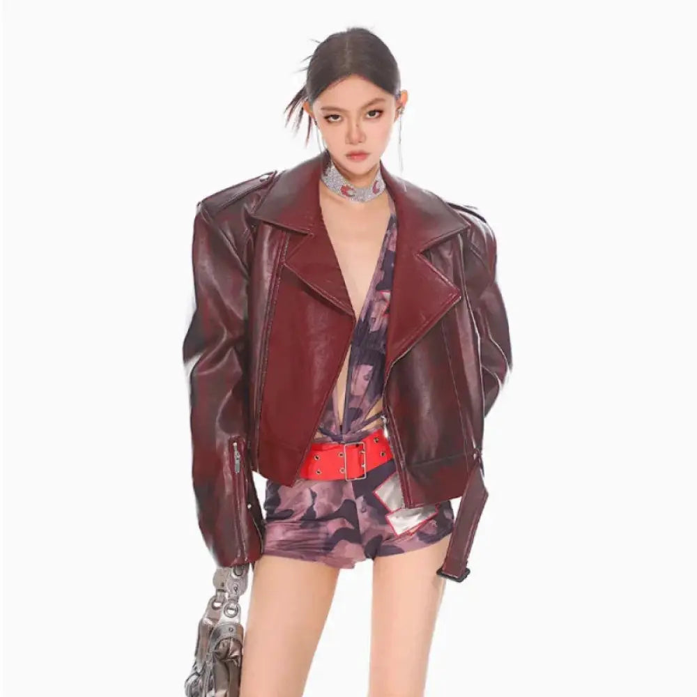 A glossy burgundy leather moto jacket with a classic collar and zipper closure for stylish outerwear
