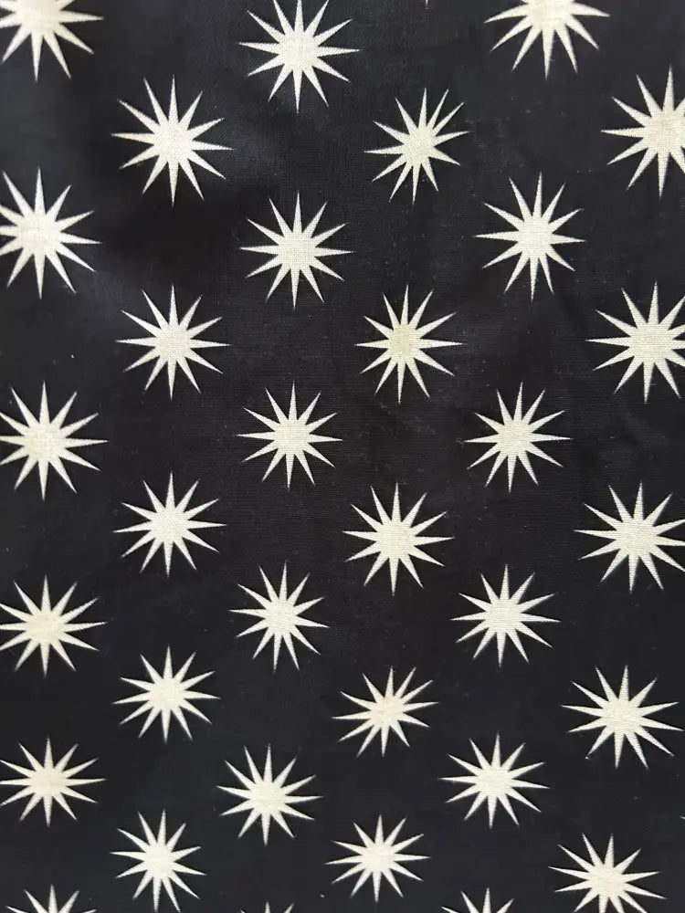 Black cotton fit and flare dress with pockets featuring a white starburst retro pattern on black fabric
