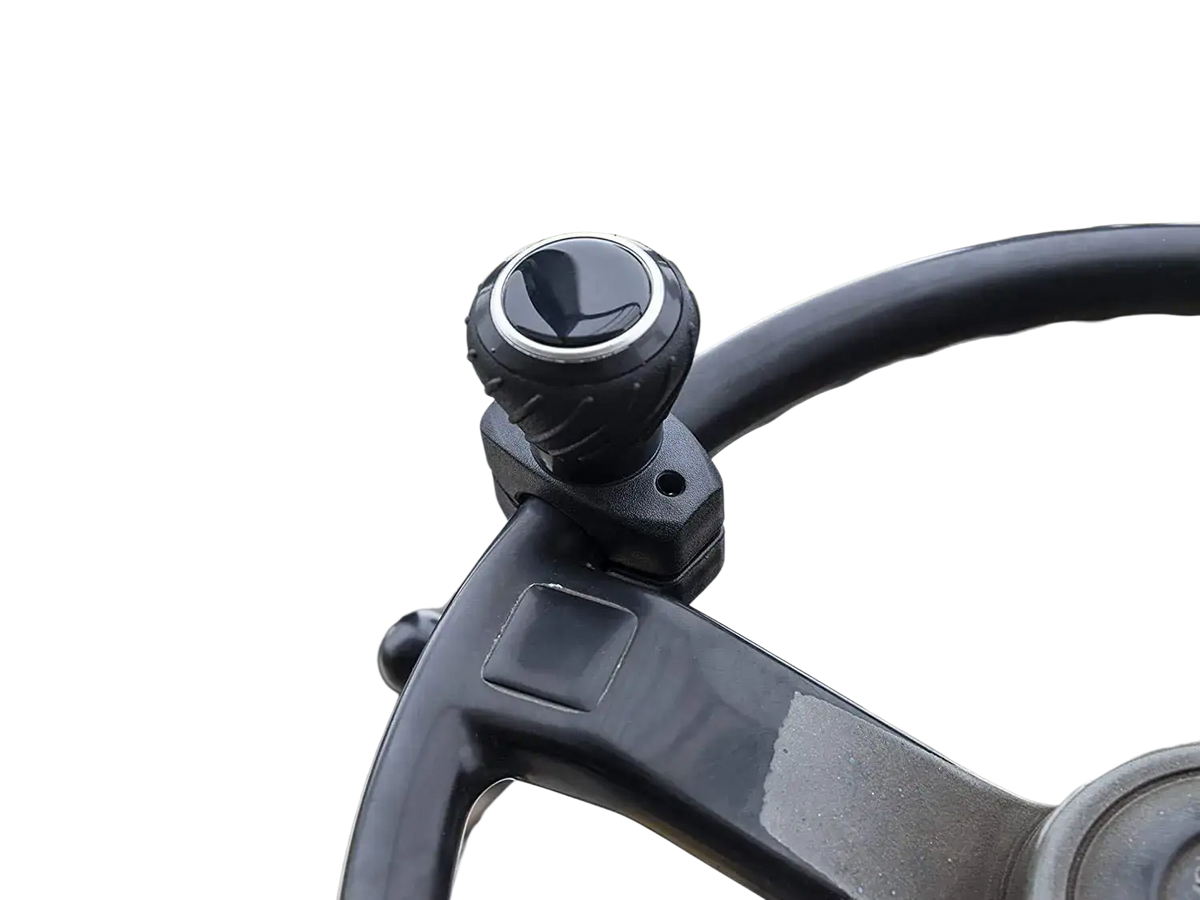 Black textured ergonomic steering wheel spinner knob with silver accent ring mounted on forklift steering column