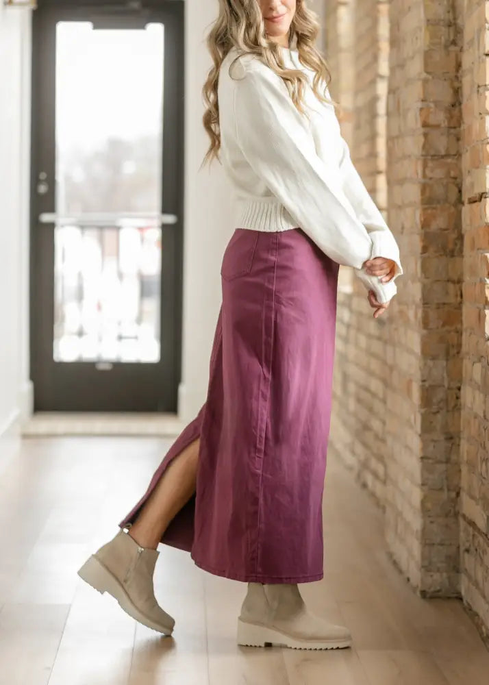 A flowing deep purple high waisted denim midi skirt with a side slit and subtle vertical seams by Stella Orchid