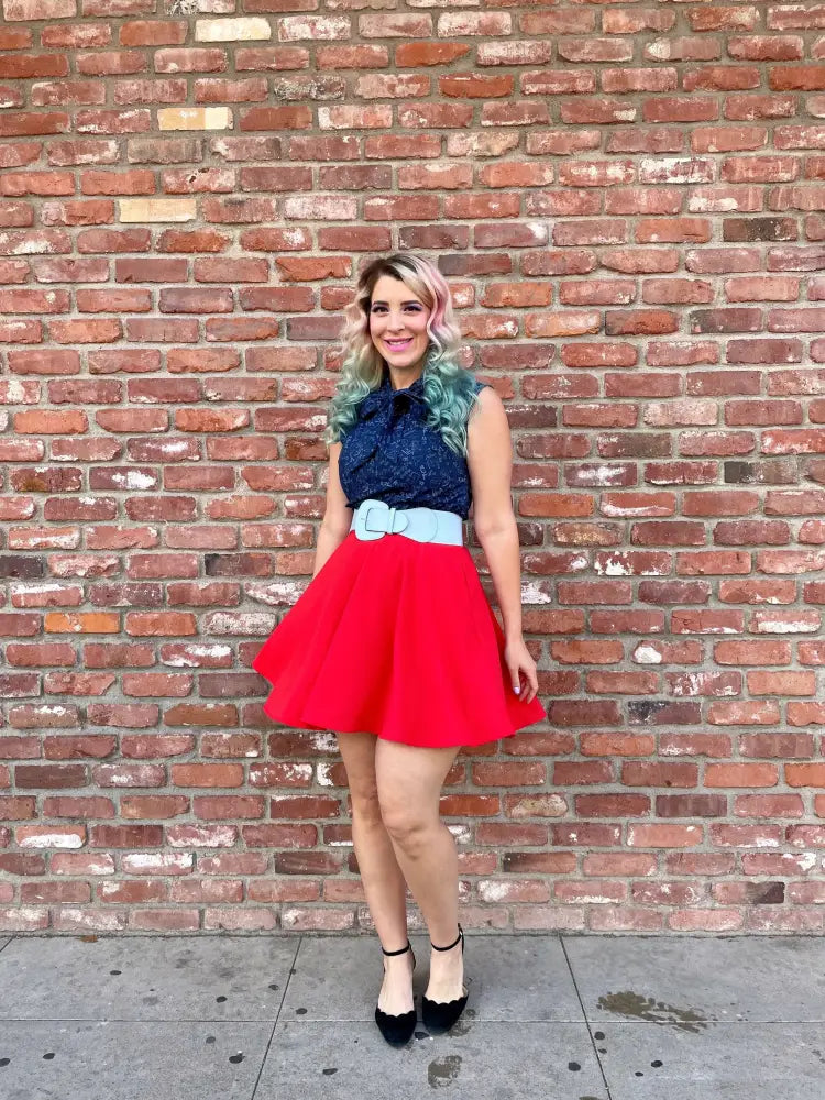 A vibrant red flared skirt with high waist and light blue belt paired with a navy lace bow top featuring mathematical symbols