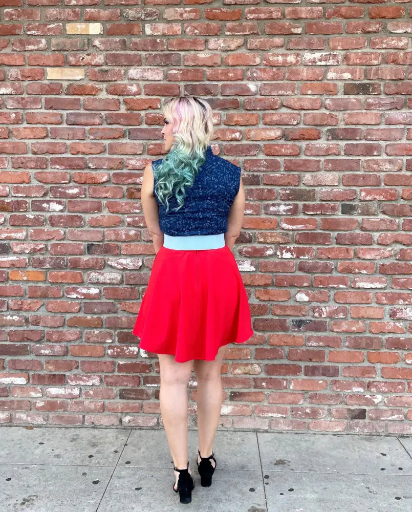 A vibrant red pleated skirt with a contrasting light blue waistband paired with a stem print navy lace bow top featuring mathematical symbols