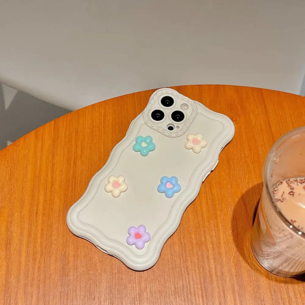 Back side of a 3d pastel floral textured silicone phone case with cream base and 3d light blue pink and lavender flowers