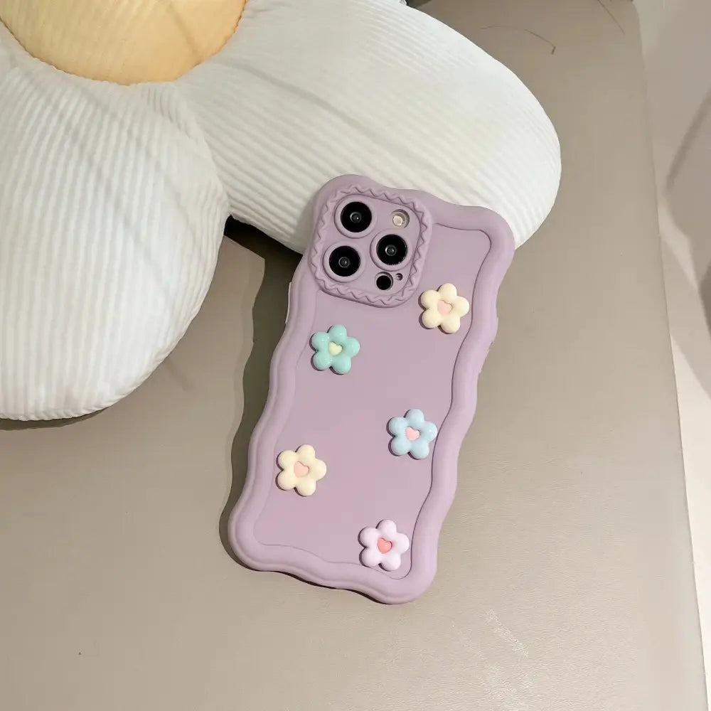 Back side of a lavender silicone phone case with pastel 3d floral texture and scalloped edge design