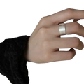 A sleek silver-toned sterling silver beaded open ring with a textured surface worn on a finger