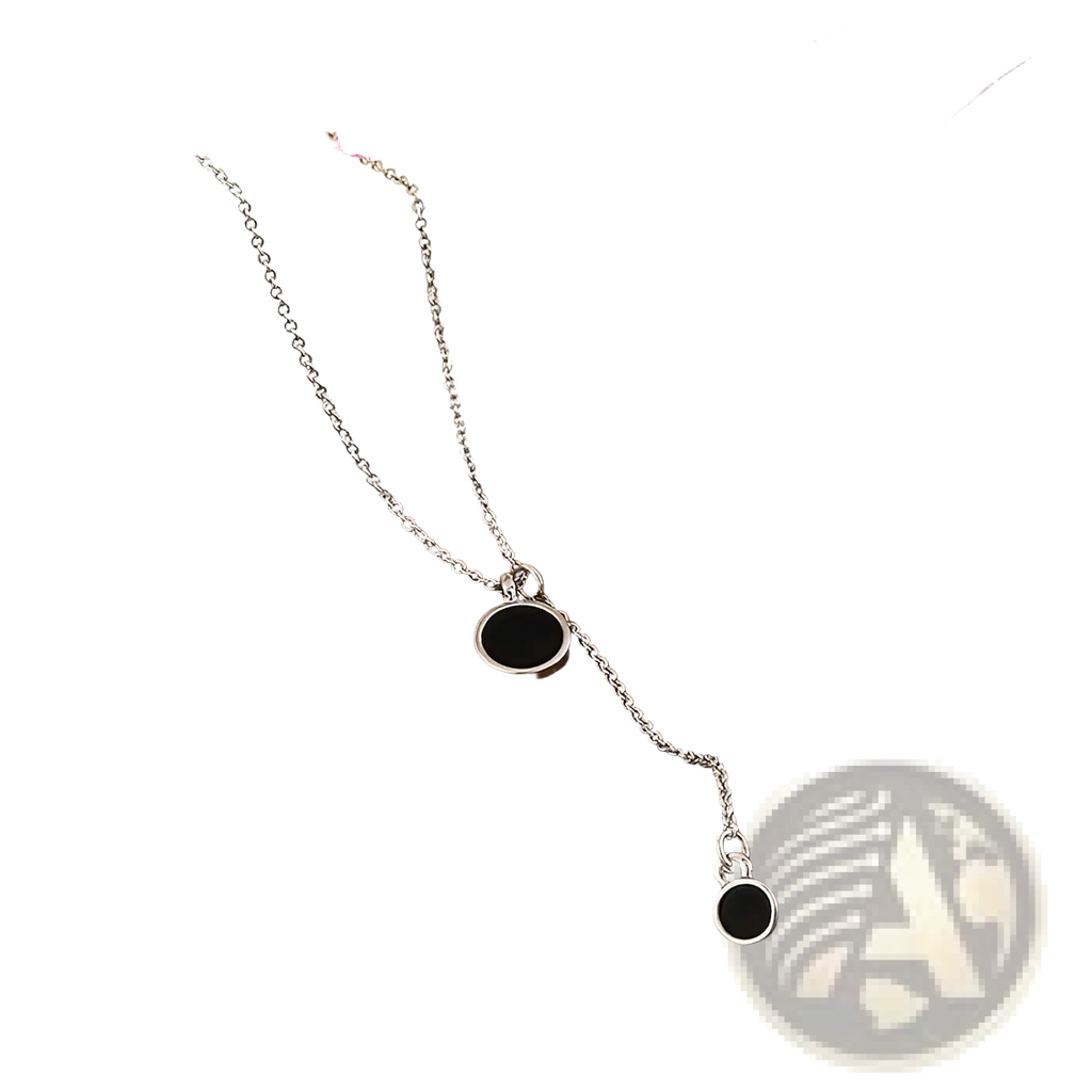Sterling silver necklace with two black circular pendants featuring a delicate minimalist design