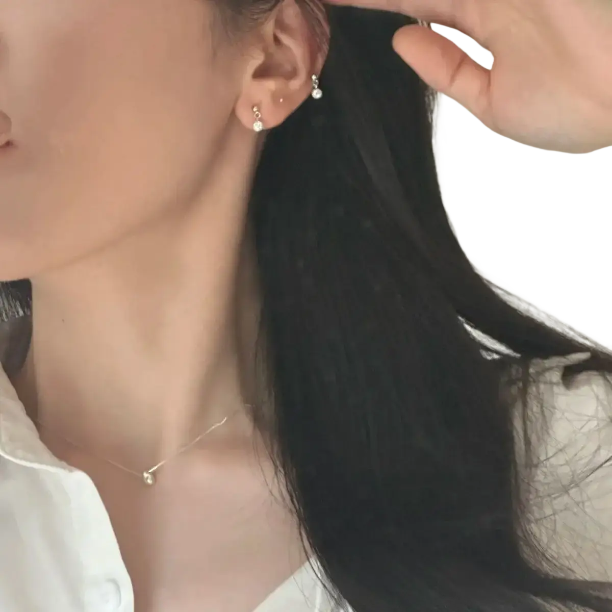 Delicate sterling silver stud earrings with tiny dangling crystal accents complementing geometric pendant necklace