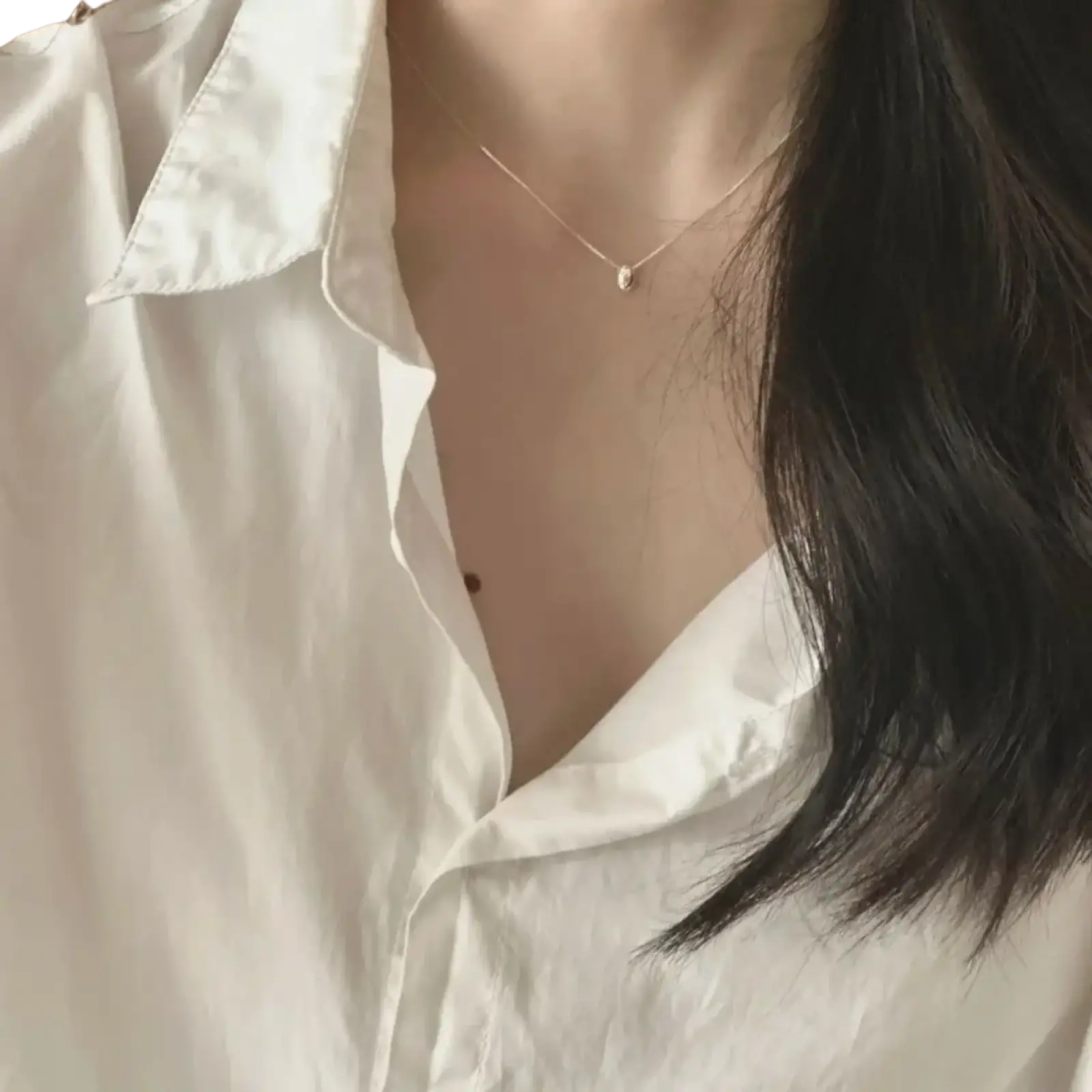 A delicate gold-toned sterling silver geometric pendant necklace with a small oval-shaped pendant against the skin