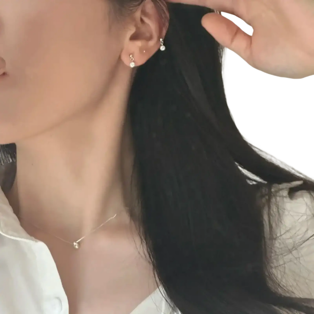 Delicate sterling silver stud earrings with tiny dangling crystal accents complementing geometric pendant necklace