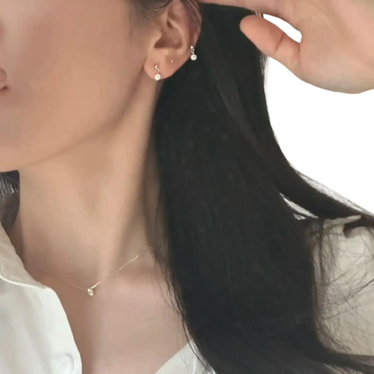 Delicate sterling silver stud earrings with tiny dangling crystal accents complementing geometric pendant necklace