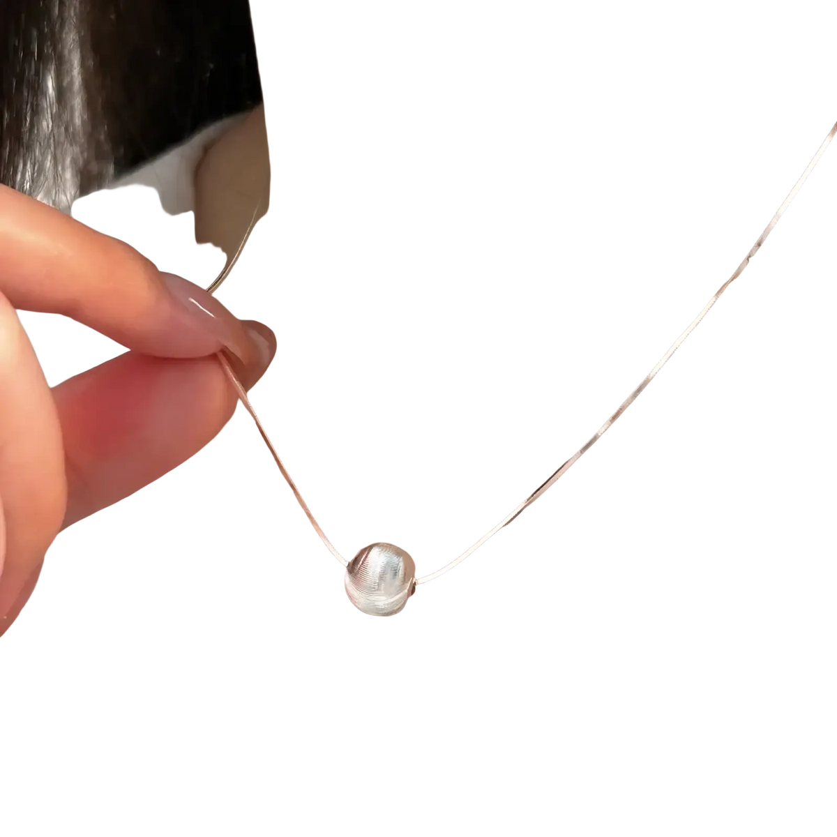 A sleek sterling silver pendant necklace with a textured silver spherical pendant on an elegant chain