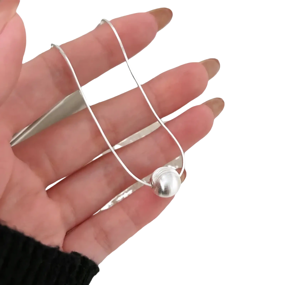 Sterling silver pendant necklace featuring a silver snake chain with a polished spherical pendant minimalistic design
