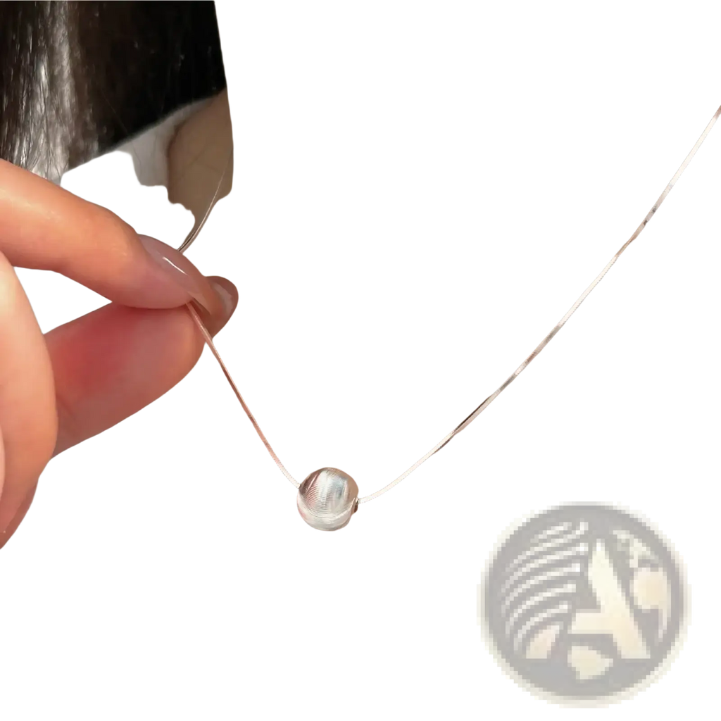 A sleek silver spherical sterling silver pendant necklace with a delicate chain and subtle textured surface