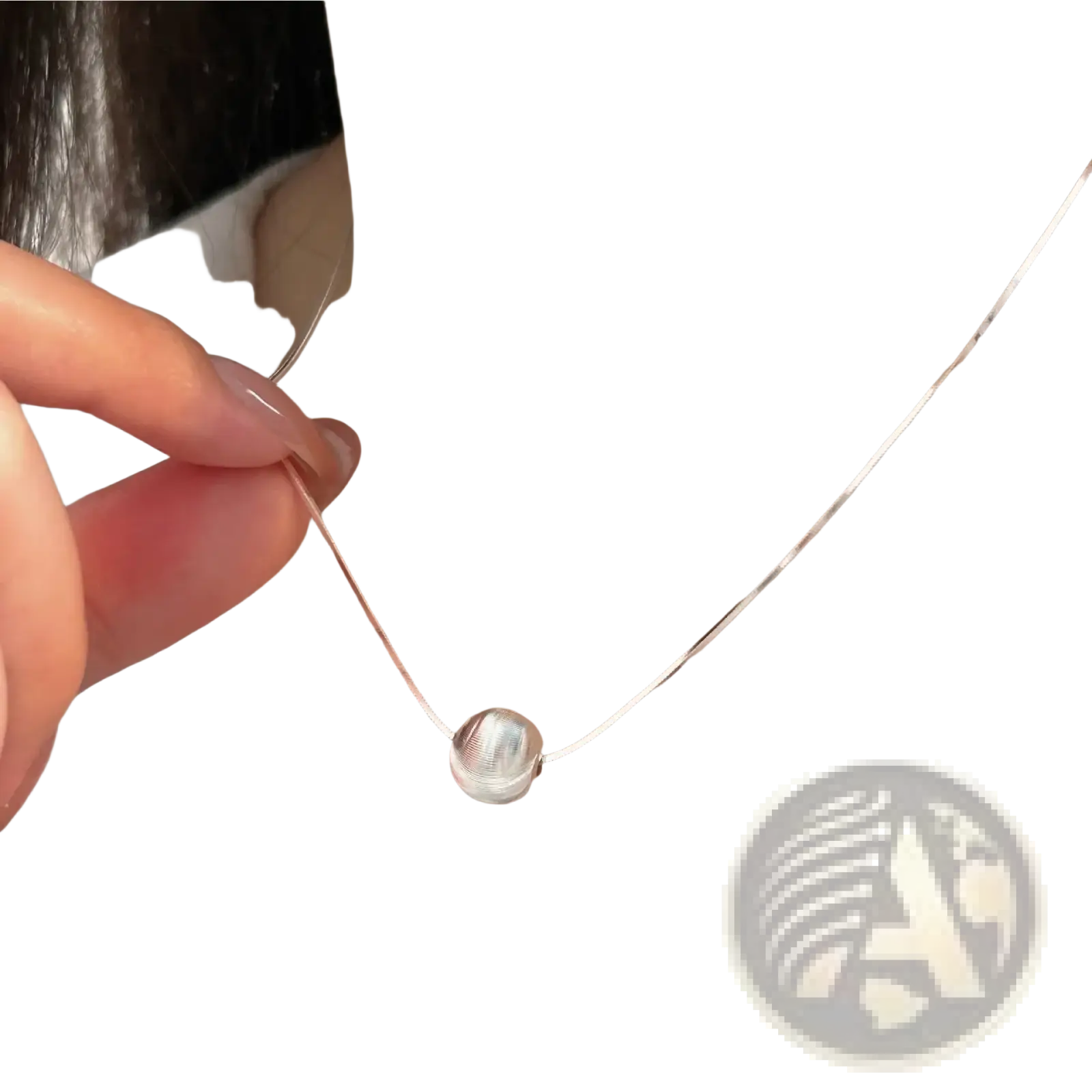 A sleek silver spherical sterling silver pendant necklace with a delicate chain and subtle textured surface