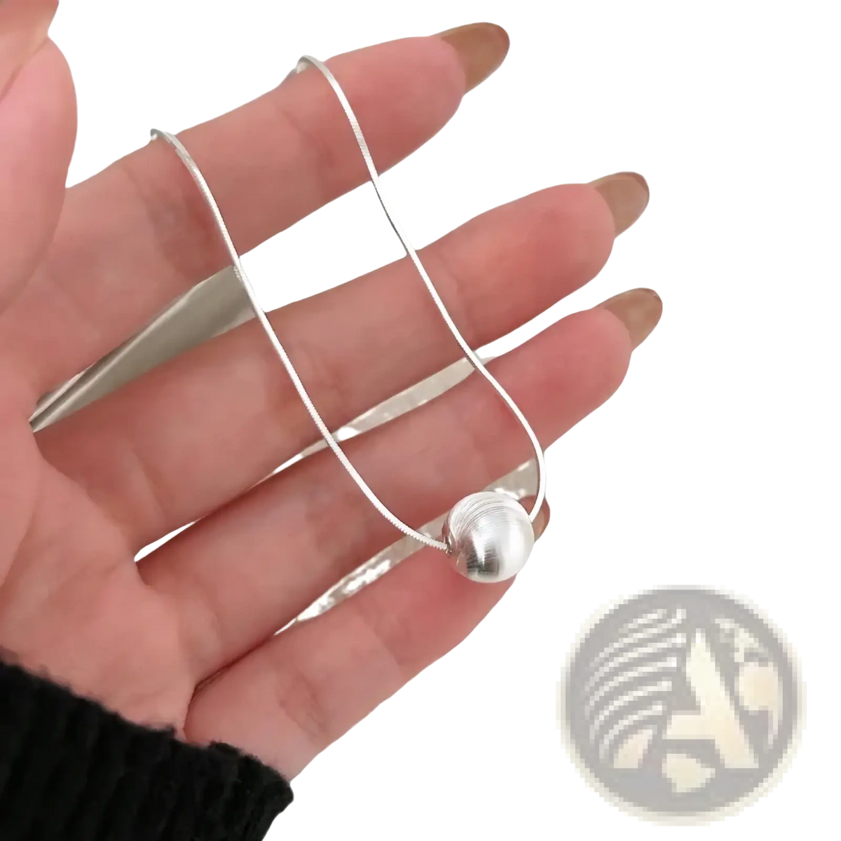 Sterling silver pendant necklace featuring a silver snake chain with a polished spherical pendant minimalistic design