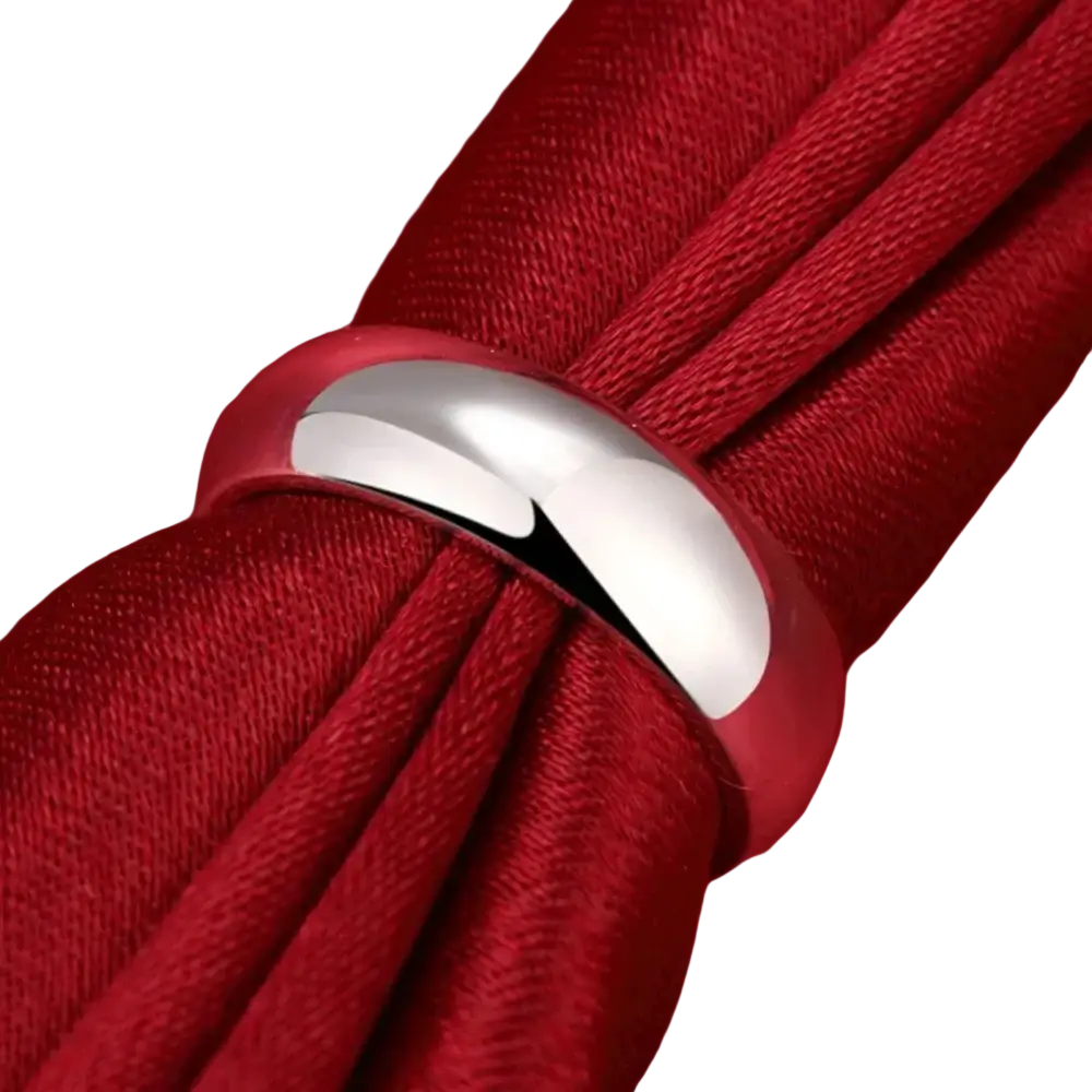 A high quality sterling silver ring minimalist starburst band with a smooth polished finish on red fabric