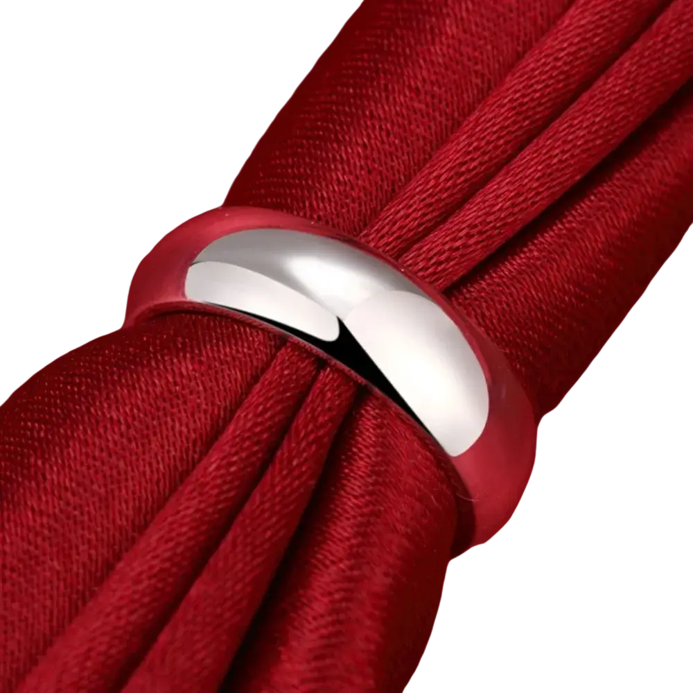 A sleek sterling silver round band ring in sizes 5 to 10 resting on red fabric for high quality fashion jewelry luxury
