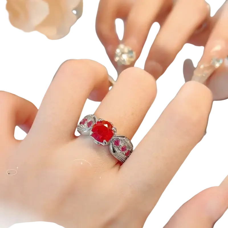 Sterling silver ruby gemstone ring for women with a central red stone and two smaller red stones in an ornate design