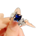Sterling silver ring for women with a square-cut deep blue sapphire and butterfly motifs with clear stones