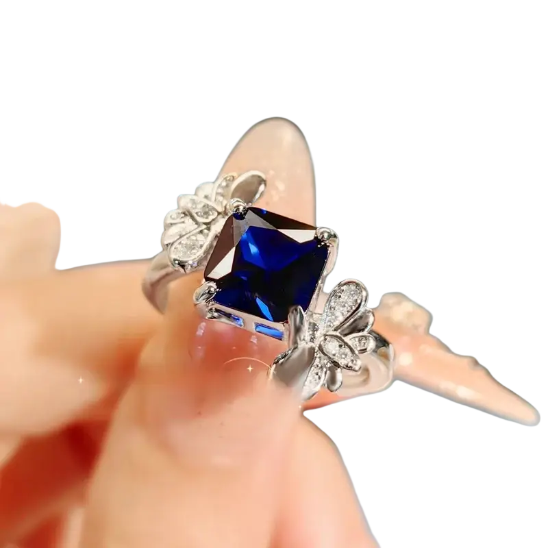 Sterling silver ring for women with a square-cut deep blue sapphire and butterfly motifs with clear stones