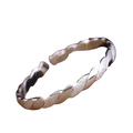 Sterling silver twisted bangle bracelet with a sleek textured glittering surface and polished metallic finish