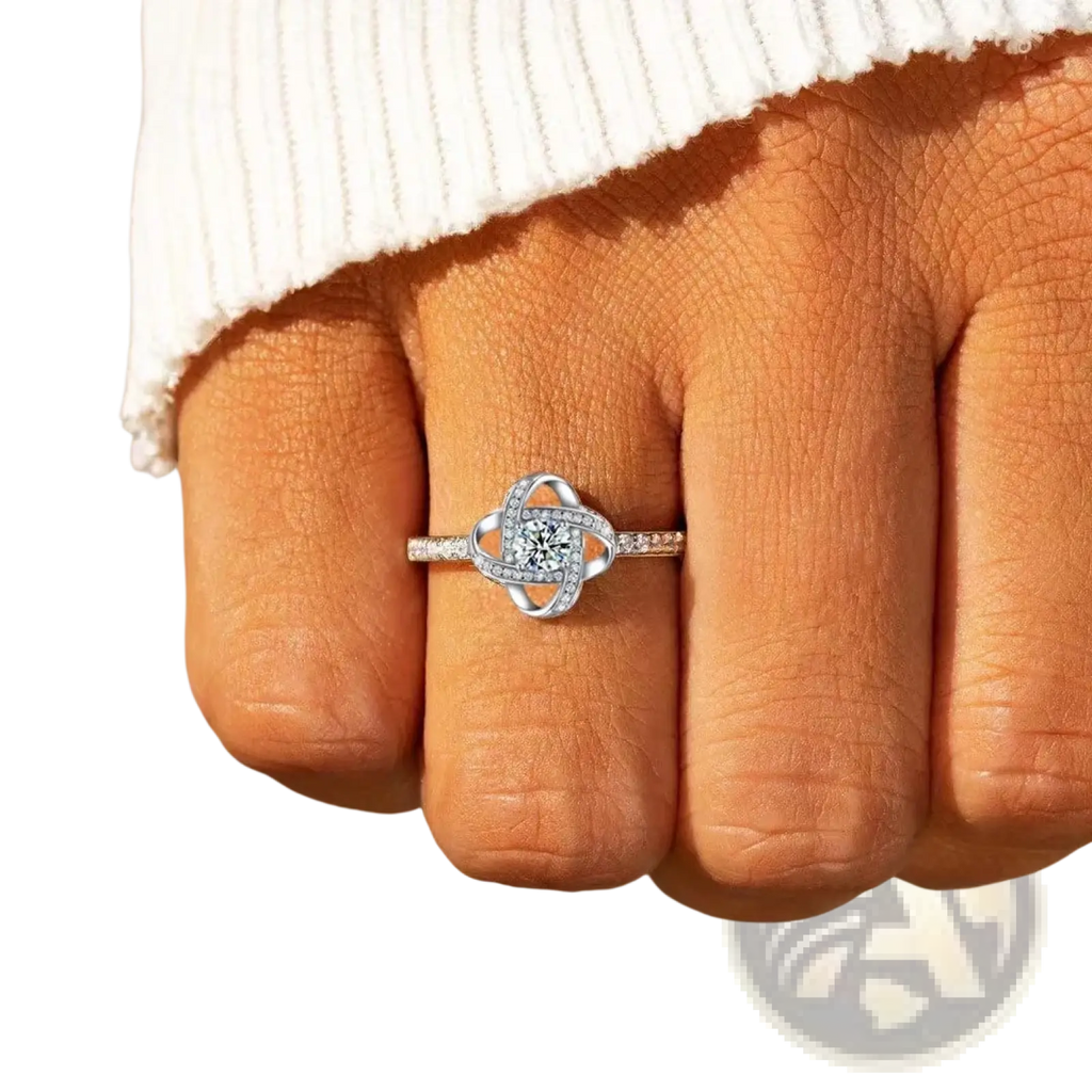 Sterling silver zircon knot ring featuring a central round diamond surrounded by smaller diamonds in an intricate design