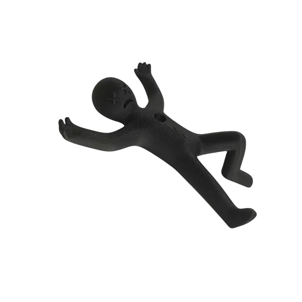 Black plastic stick figure pen holder desk organizer with x-shaped face and textured surface lying on its back