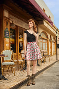 Pink christmas stockings festive cotton skater skirt with green and red candy cane pattern worn by woman outside bakery