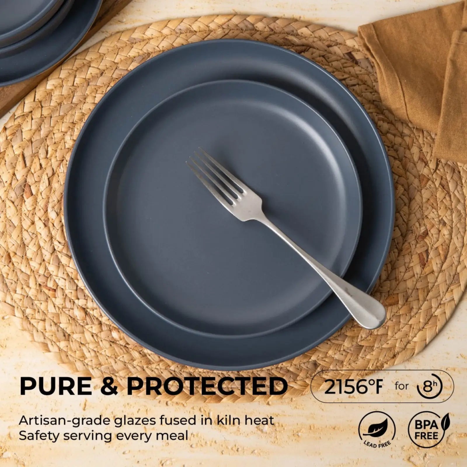 Set of 12 piece matte gray stoneware dinnerware plates with a matte finish arranged on a woven placemat