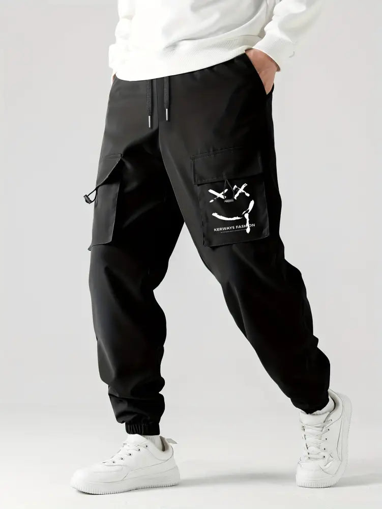 Men’s black tactical wear resistant cargo joggers with pockets and a white smiley face on the thigh pocket