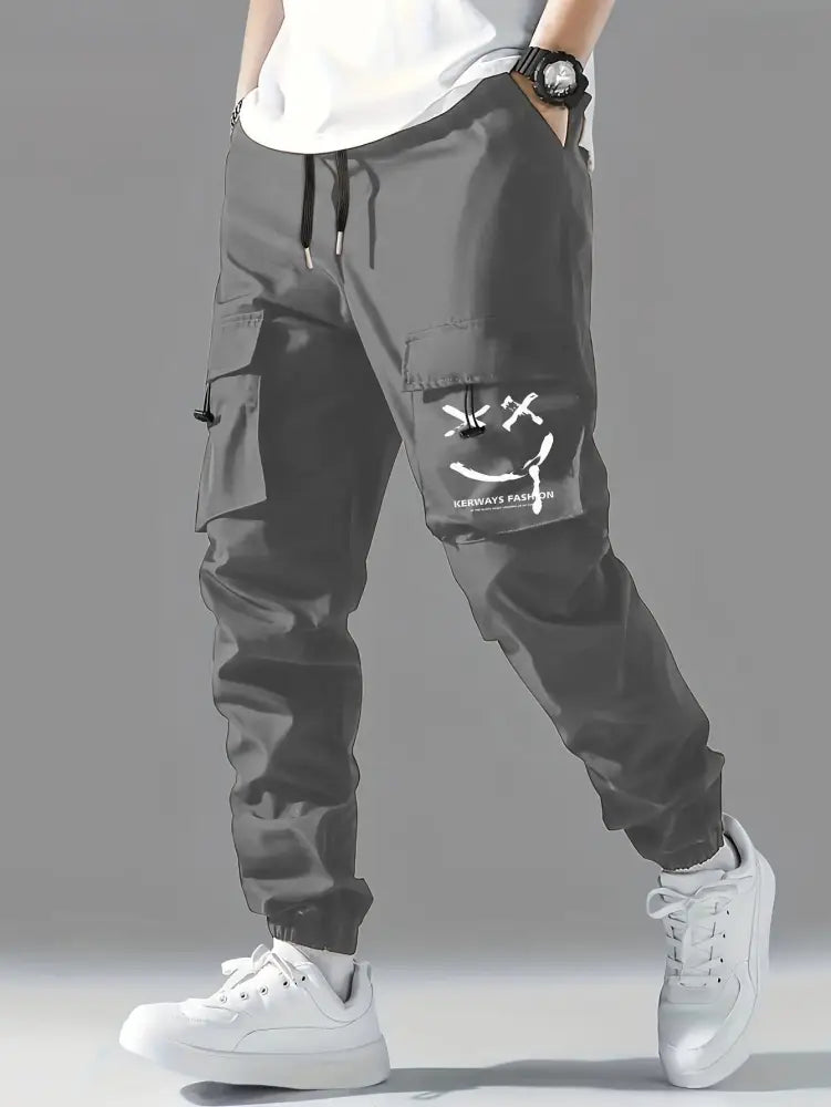 Men’s dark gray wear resistant tactical cargo joggers with pockets and a white smiley face graphic on the thigh pocket