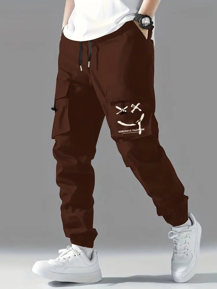Men’s brown tactical wear resistant cargo joggers with pockets featuring a white smiley face graphic and black drawstrings