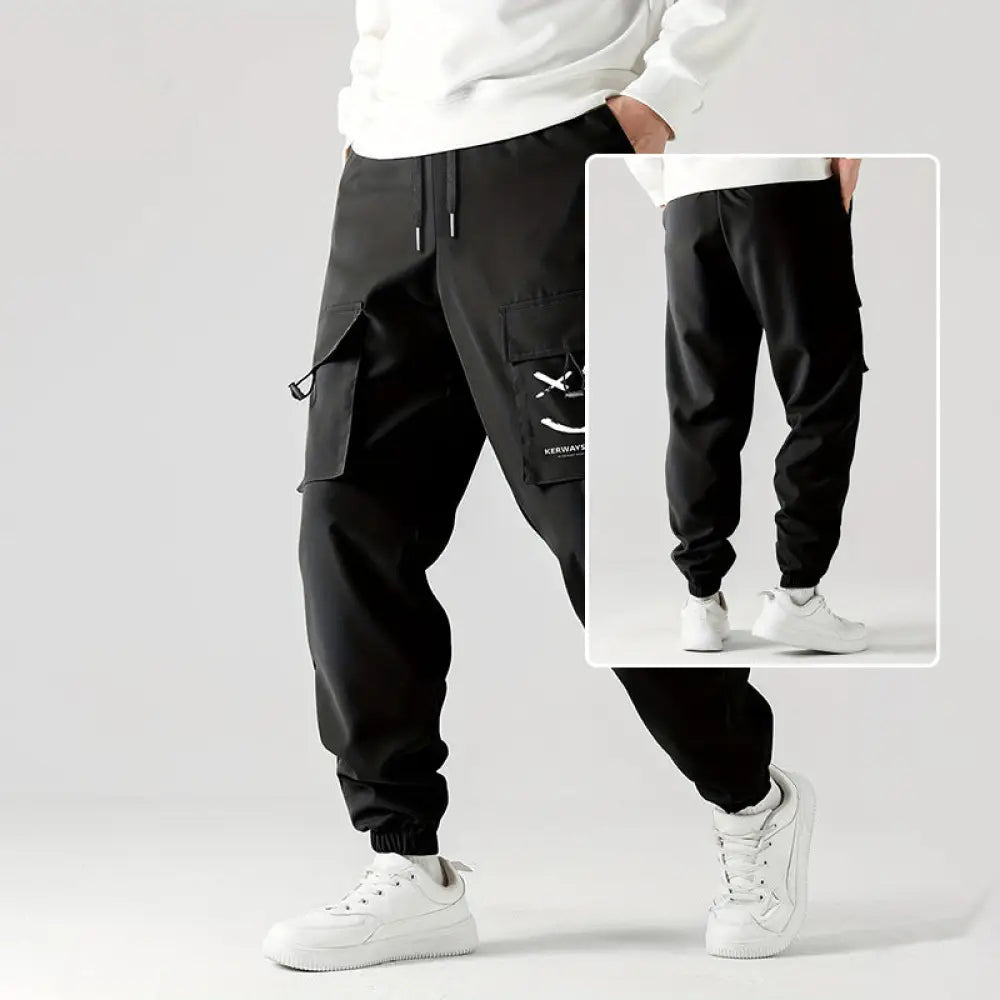 Men’s black tactical wear resistant cargo joggers with multiple pockets and a white logo patch on the thigh