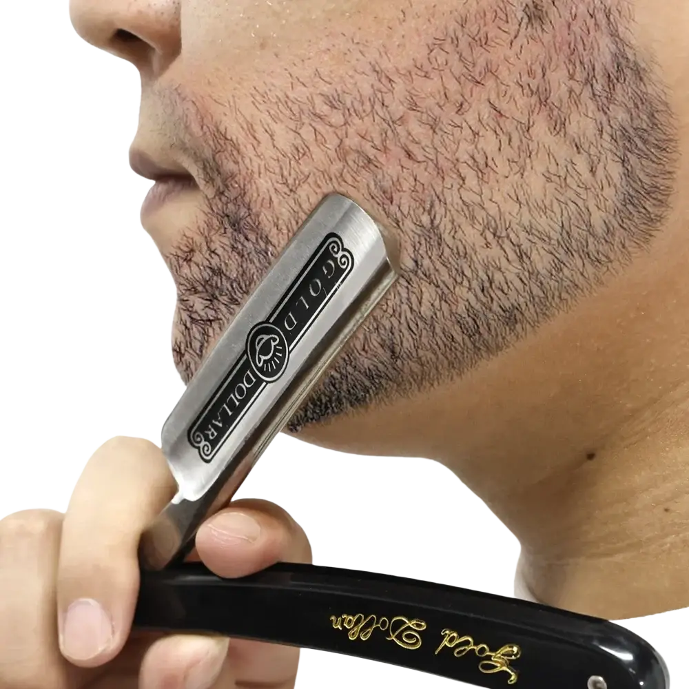 A sleek black-handled straight edge barber razor with polished silver blade engraved with gold dollar emblem