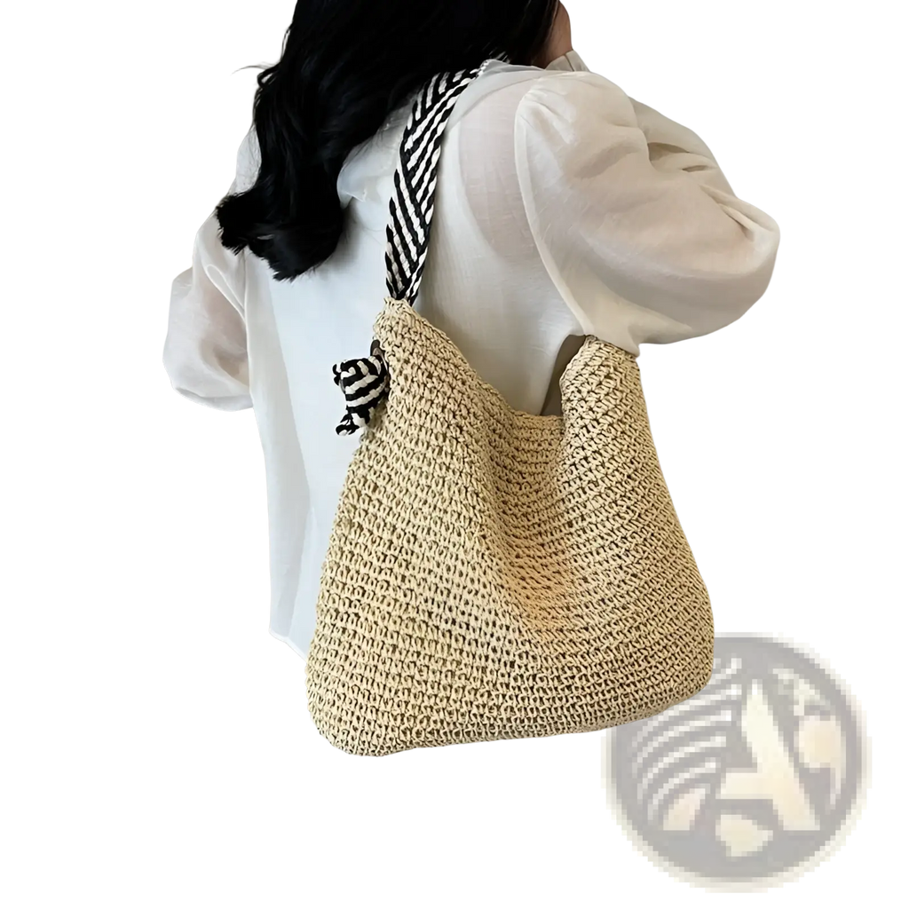 Beige woven straw tote bag with black and white striped shoulder strap and striped bow handles for stylish carrying