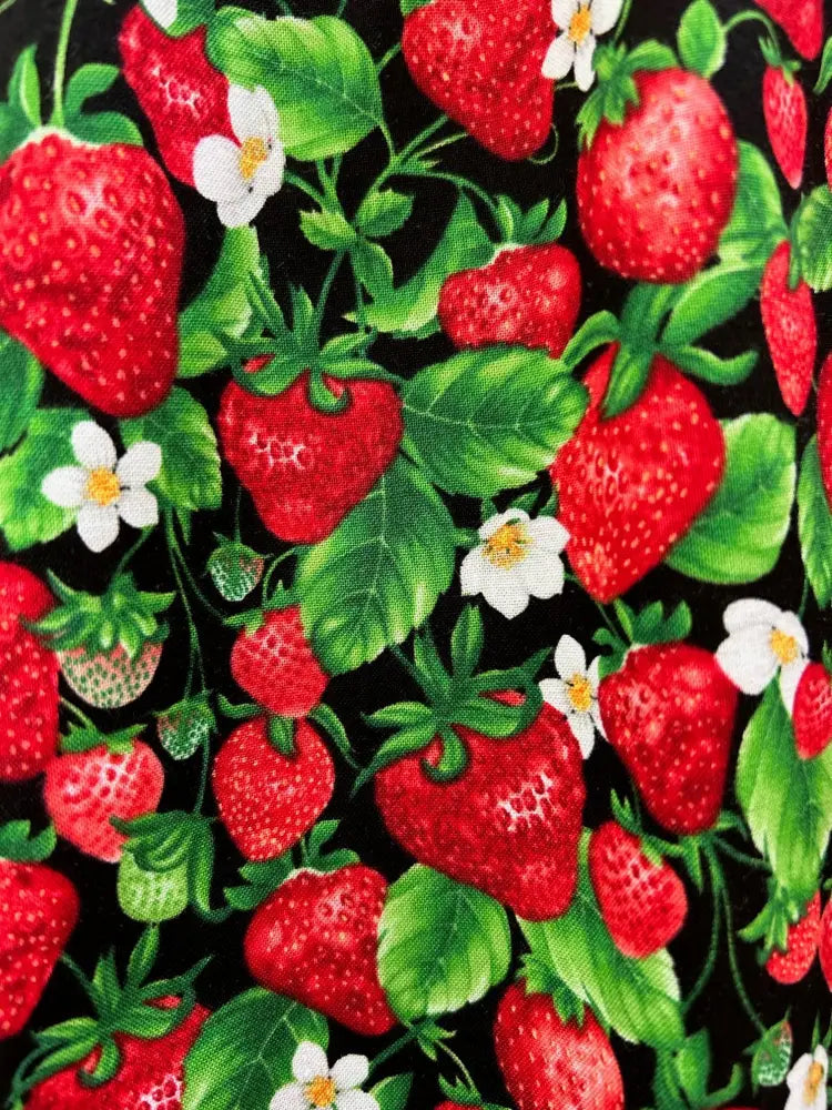 Black vintage cotton a line skirt with pockets featuring a vibrant red strawberry pattern with green leaves and white flowers