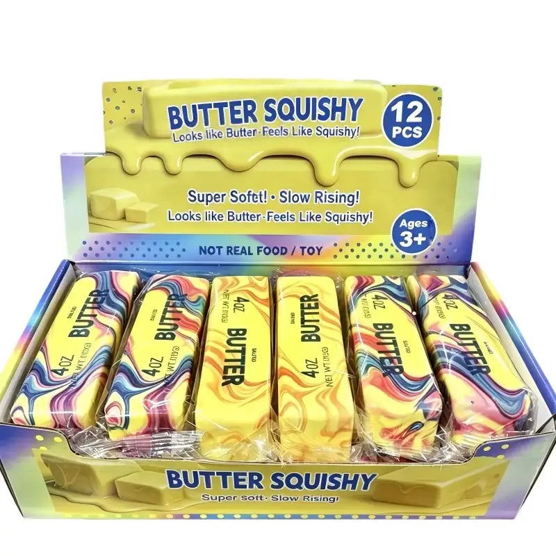 Yellow and rainbow-marbled butter-shaped slow rising squishy toys in a display box for sensory play