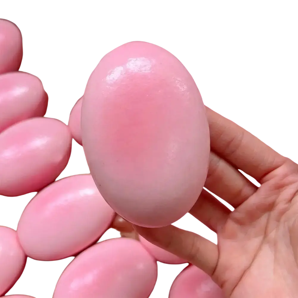 A smooth glossy pink slow rising cheesecake squishy toy with a translucent appearance for stress relief