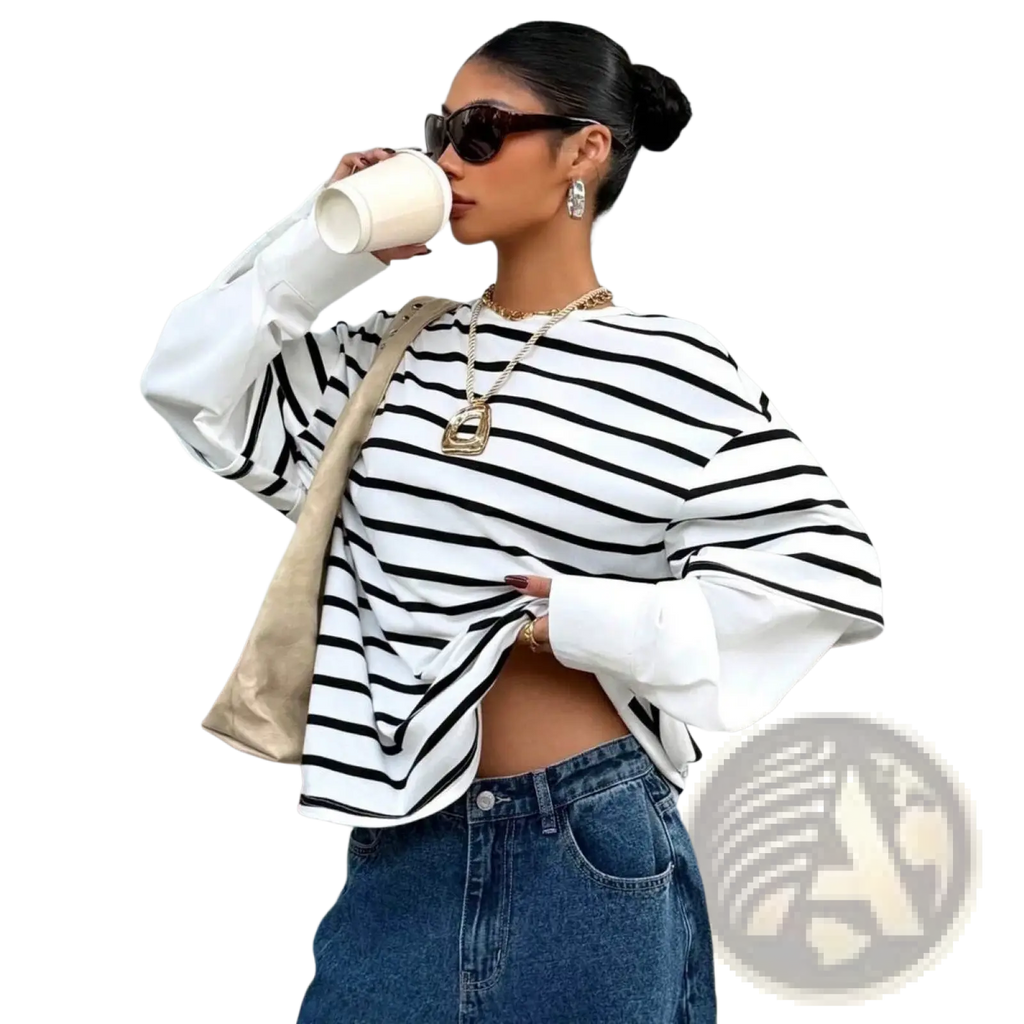 A woman wearing a black and white striped long-sleeve top with balloon sleeves in a striped mock two piece oversized hoodie